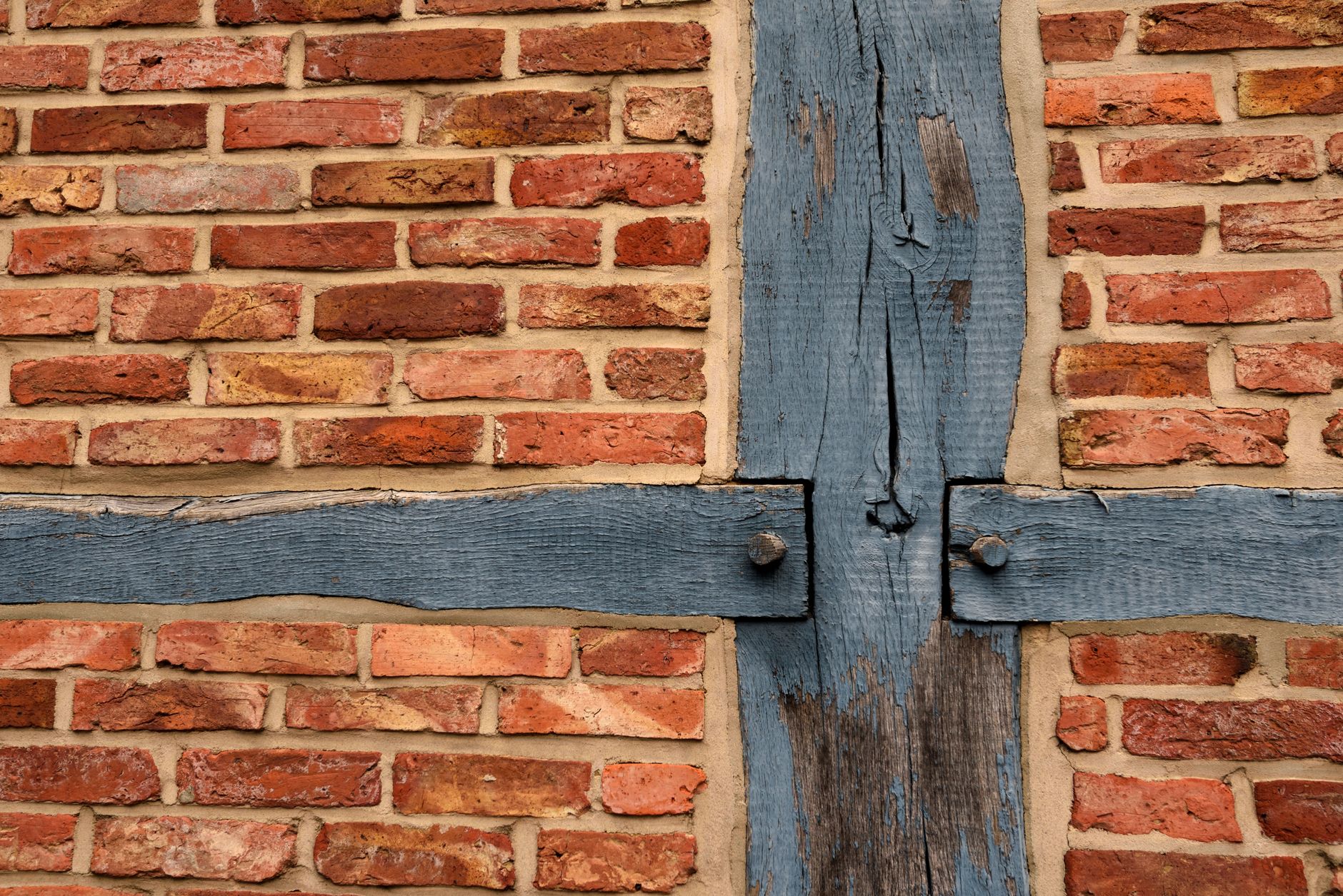 Close-up of a historic half-timbered brick wall in Otterndorf, Germany with wooden beams.